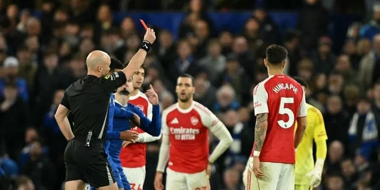 Wasit Anthony Taylor (kiri) memberikan kartu merah kepada Moises Caicedo (tidak ada dalam gambar) dalam pertandingan sepak bola Liga Inggris antara Chelsea vs Arsenal di Stamford Bridge di London pada 30 November 2025. (Foto oleh JUSTIN TALLIS / AFP)