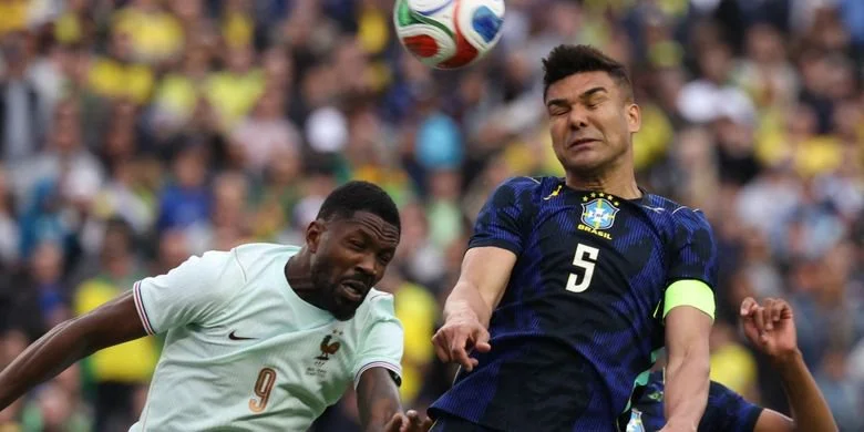 Gelandang timnas Brasil, Casemiro, menyundul bola melawan penyerang timnas Perancis Marcus Thuram pada laga persahabatan antara Brasil dan Prancis di Stadion Gillette di Foxborough, Massachusetts, pada 26 Maret 2026.