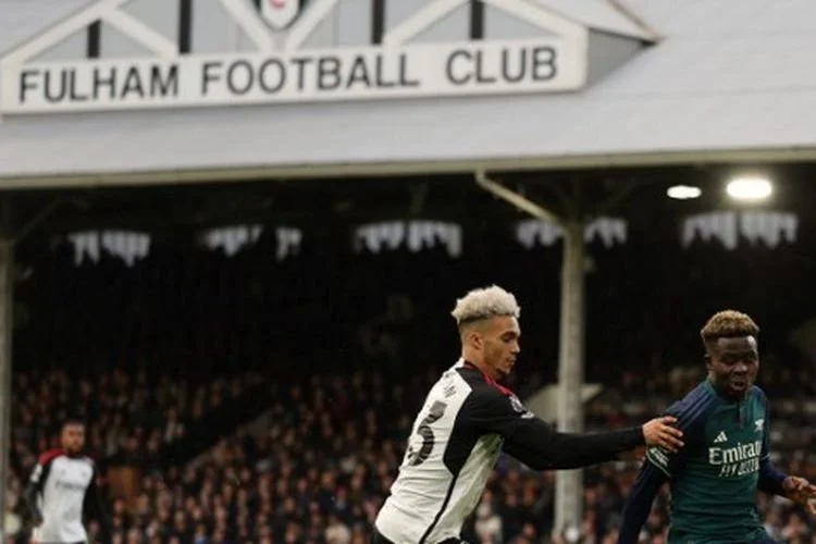 Bukayo Saka (kanan) dan Antonee Robinson (kiri) berebut bola dalam pertandingan Fulham vs Arsenal pada pekan ke-20 Liga Inggris 2023-2024 di Craven Cottage, Minggu (31/12/2023). 