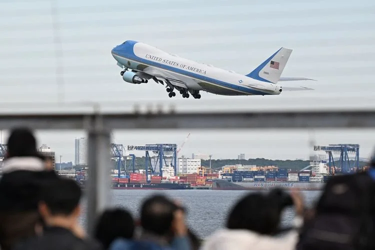 Orang-orang menyaksikan pesawat kepresidenan Amerika Serikat, Air Force One, lepas landas dari Bandara Haneda di Tokyo, Jepang, 29 Oktober 2025.