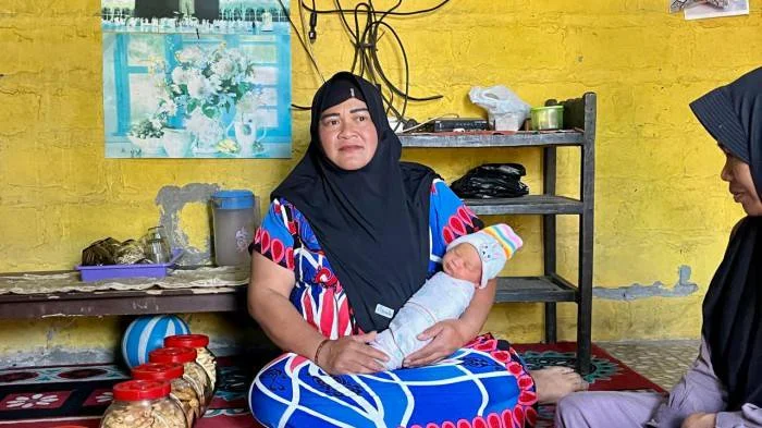 NAMA UNIK - Yuharni memperlihatkan putra ketiganya yang diberi nama Muhammad MBG Subianto di rumahnya di Dusun Prigi, Desa Jolontoro, Kecamatan Sapuran, Kabupaten Wonosobo, Senin (13/7/2026). Nama tersebut dipilih sebagai ungkapan syukur setelah dirinya memperoleh pekerjaan di SPPG melalui Program Makan Bergizi Gratis (MBG).