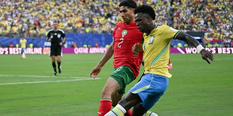 Achraf Hakimi berebut bola dengan Vinicius Junior dalam pertandingan sepak bola Grup C Piala Dunia 2026 Brasil vs Maroko di Stadion New York/New Jersey di East Rutherford pada 13 Juni 2026. (Foto oleh Mauro PIMENTEL / AFP)