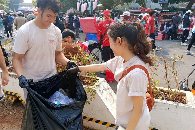 Sejumlah anggota Komunitas Pemilah Sampah (PCM) Jakarta saat sedang mengumpulkan sampah pada momen Hari Bebas Kendaraan Bermotor (HBKB) atau Car Free Day di kawasan Jalan Jenderal Sudirman-MH Thamrin, Jakarta Pusat, Minggu (2/8/2026).