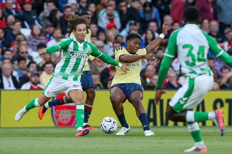 Myles Lewis-Skelly (tengah), mendapat hadangan dalam pertandingan pramusim antara Arsenal dan Real Betis di Stadion Aviva, Dublin, Irlandia, pada 5 Agustus 2026.