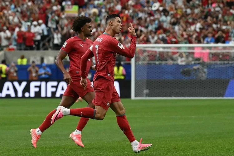 Cristiano Ronaldo (kanan) merayakan gol pembuka dalam pertandingan sepak bola Grup K Piala Dunia 2026 antara Portugal vs Uzbekistan di Stadion Houston di Houston pada 23 Juni 2026. (Foto oleh RONALDO SCHEMIDT / AFP)