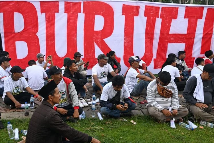 Sejumlah buruh duduk saat mengikuti peringatan Hari Buruh Internasional atau May Day 2026 di kawasan Monumen Nasional (Monas), Jakarta, Jumat (1/5/2026). Dalam May Day 2026 para buruh menuntut adanya pengesahan RUU Ketenagakerjaan, penghapusan outsourcing dan penolakan upah murah, hingga kekhawatiran terhadap dampak konflik global yang berpotensi memicu gelombang pemutusan hubungan kerja (PHK). 