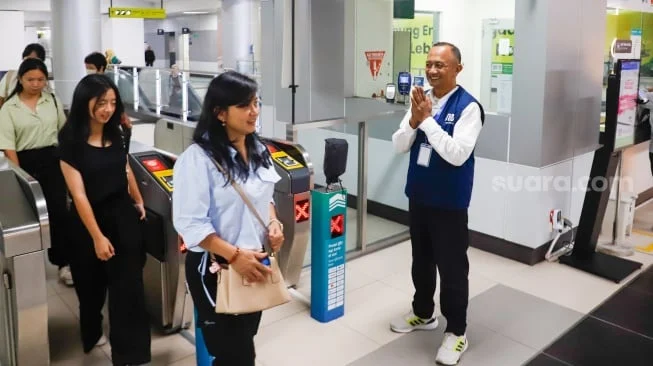 Pekerja lanjut usia (lansia) menyapa pengguna MRT Jakarta di Stasiun Bundaran HI, Jakarta, Selasa (3/6/2025). [Suara.com/Alfian Winanto]