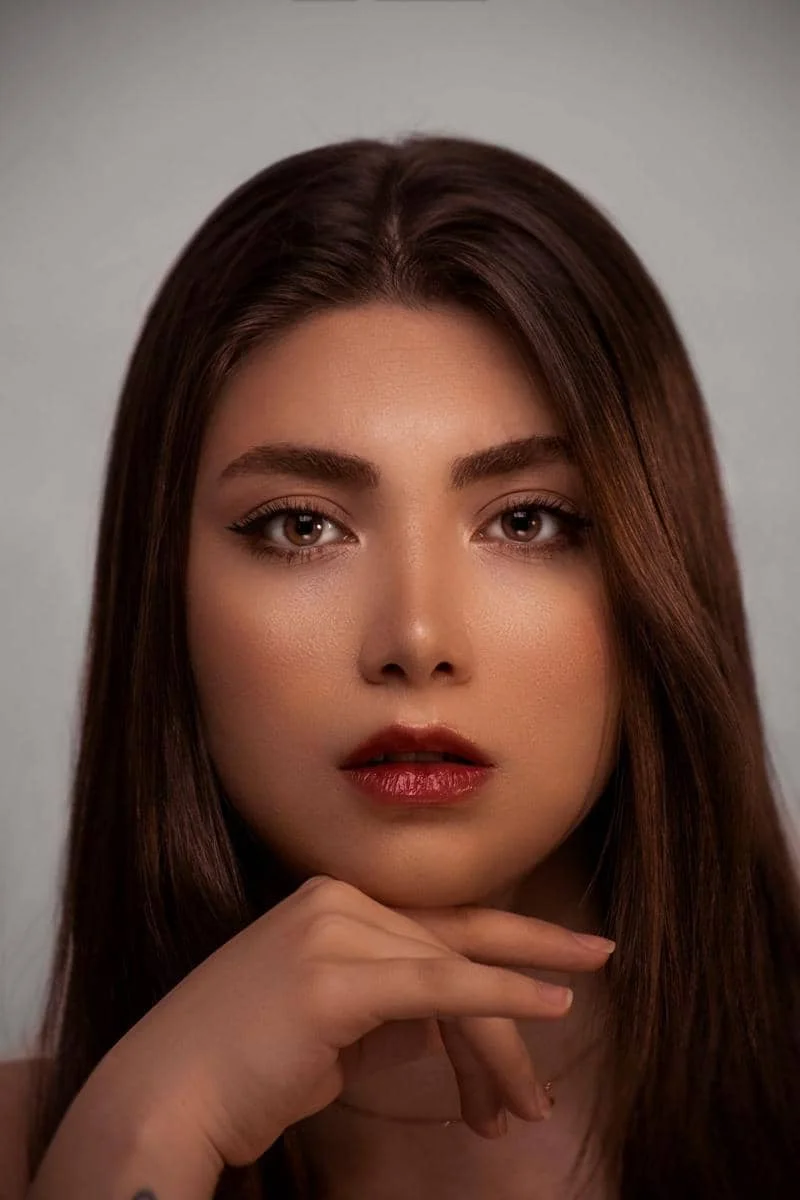 Wajah seorang wanita dengan riasan make up shimmer dan highlight yang memberikan efek glow alami pada kulitnya.