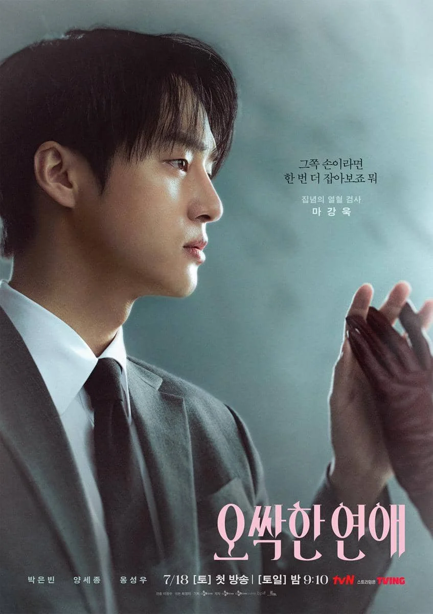Seorang pria mengenakan setelan jas abu-abu menatap tangan berbalut sarung tangan hitam dalam poster drama Korea Spooky in Love.