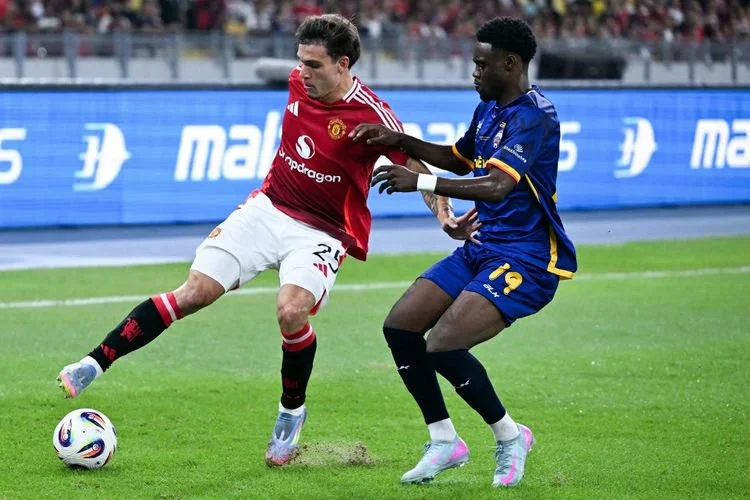 Manuel Ugarte (kiri) dari Manchester United berebut bola dengan Yaya Dukuly (kanan) dari Asean All-Stars pada pertandingan persahabatan eksibisi antara Manchester United dan Asean All-Stars di Stadion Nasional Bukit Jalil di Kuala Lumpur pada 28 Mei 2025.