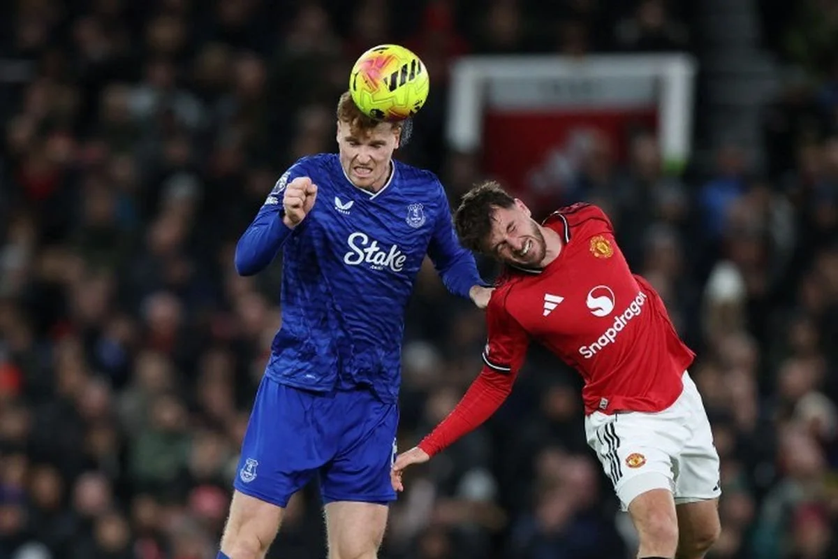 Jake O'Brien (kiri) berduel bola udara dengan Mason Mount (kanan) dalam pertandingan sepak bola Liga Inggris antara Manchester United vs Everton di Old Trafford di Manchester, barat laut Inggris, pada 24 November 2025. (Foto oleh Darren Staples / AFP)