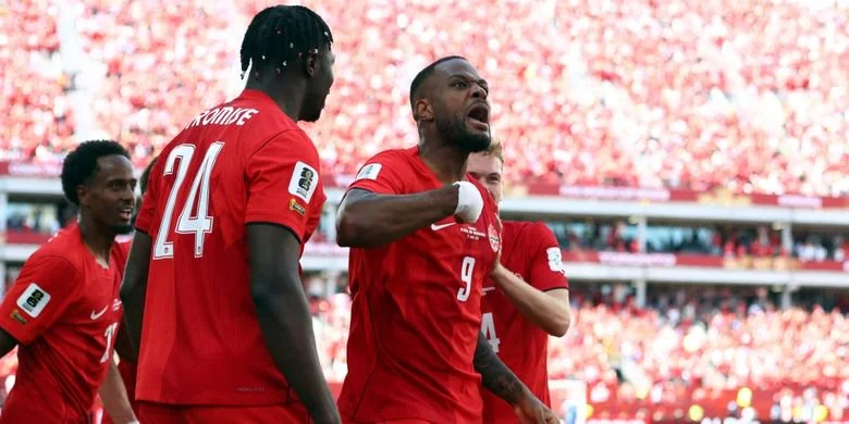 Cyle Larin (kanan) merayakan gol dalam pertandingan sepak bola Grup B Piala Dunia 2026 antara Kanada vs Bosnia-Herzegovina di Stadion Toronto di Toronto pada 12 Juni 2026. (Foto oleh Cole Burston / AFP)