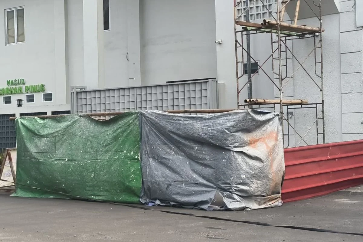 Sisi jalan yang ditutup oleh kuli bangunan selama proses pembongkaran gapura di Taman Royal, Cipondoh , Kota Tangerang. Tujuannya agar debunya tidak beterbangan dan tidak membahayakan pengendara.