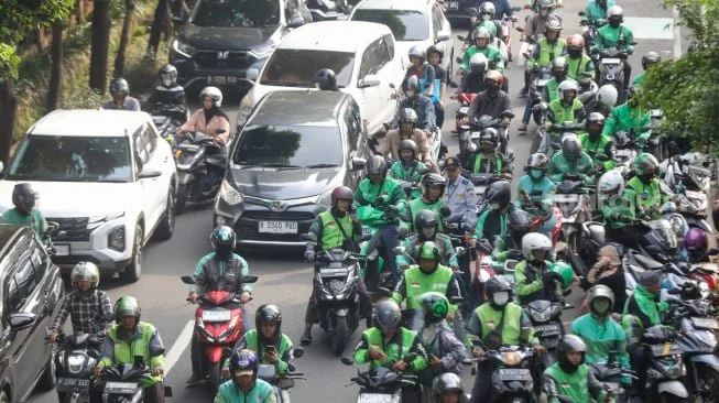 Pengemudi ojek online menunggu penumpang di seberang Stasiun Palmerah, Jakarta. [Suara.com/Alfian Winanto]