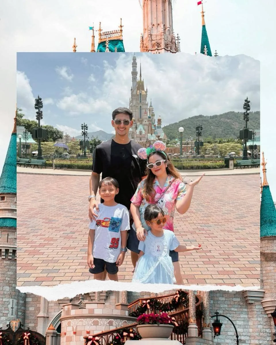 Sebuah keluarga berpose ceria di depan kastel ikonik Disneyland Hong Kong dengan latar langit cerah dan suasana liburan bahagia.