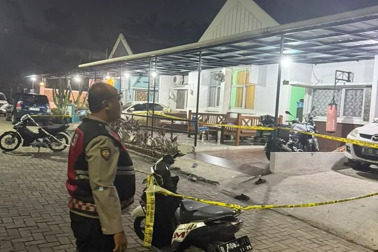 Petugas kepolisian memasang garis polisi di sekitar rumah salah satu kuasa hukum ahli waris sengketa lahan Arjuna HyperBowling di Pamulang, Tangerang Selatan, usai adanya dugaan teror menggunakan drone yang menjatuhkan benda menyerupai granat, Minggu (5/7/2026).