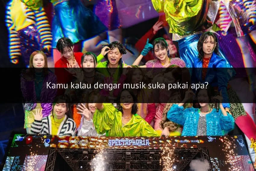 Grup idola wanita tampil di atas panggung dengan kostum warna-warni cerah dan latar bertuliskan SpectaPhoria disertai efek cahaya meriah.