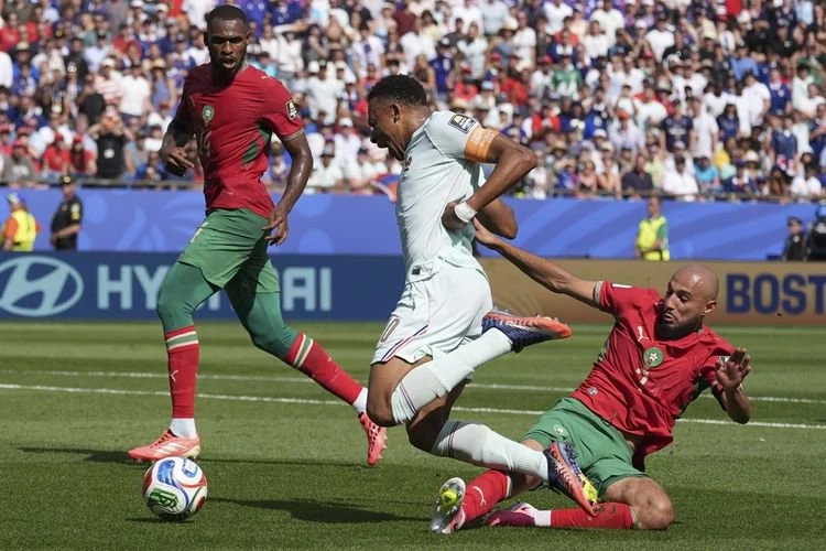 Kapten Timnas Perancis Kylian Mbappe (tengah) dilanggar oleh bek Timnas Maroko Noussair Mazraoui (kanan) selama pertandingan perempat final antara Perancis dan Maroko di Piala Dunia FIFA 2026 di Boston Stadium, Boston, Amerika Serikat, pada Jumat (10/6/2026) dini hari WIB.