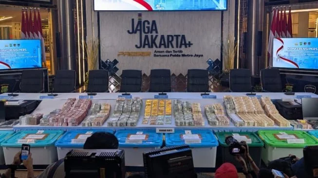Barang bukti 74 kilogram emas batangan, tumpukan uang rupiah, dolar Amerika Serikat, hingga dolar Singapura dipamerkan jelang konferensi pers di Gedung Promoter Polda Metro Jaya, Jakarta, Jumat (10/7/2026) malam.