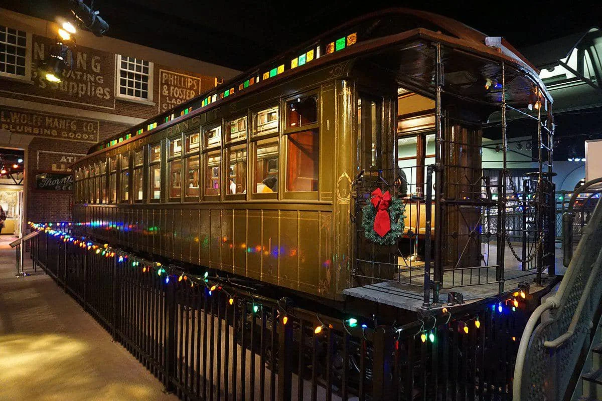 Kereta No. 1 South Side Rapid Transit berwarna cokelat tua dipamerkan di Museum Sejarah Chicago dengan hiasan lampu dan karangan bunga.
