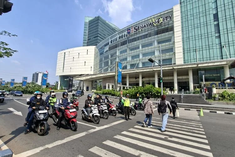 Arus lalu lintas di Jalan Asia Afrika tertahan saat ada pejalan kaki menyeberang dari area Mal Plaza Senayan menuju Mal Senayan City, Jakarta Ba