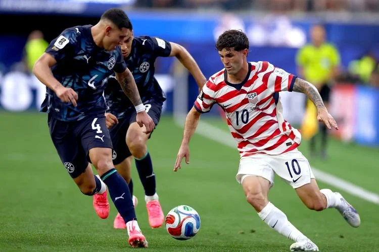 Christian Pulisic dibayangi Juan Jose Caceres dalam pertandingan Piala Dunia FIFA 2026 Grup D antara Amerika Serikat vs Paraguay di Stadion Los Angeles pada 12 Juni 2026 di Los Angeles, California. Dean Mouhtaropoulos/Getty Images/AFP (Foto oleh Dean Mouhtaropoulos / GETTY IMAGES AMERIKA UTARA / Getty Images melalui AFP)