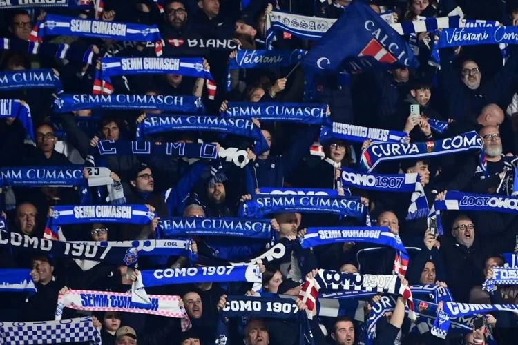 Pendukung Como melambaikan syal menjelang pertandingan sepak bola Serie A Liga Italia antara Como vs Inter Milan di Stadion Giuseppe Sinigaglia di Como pada 12 April 2026. (Foto oleh Piero CRUCIATTI / AFP)