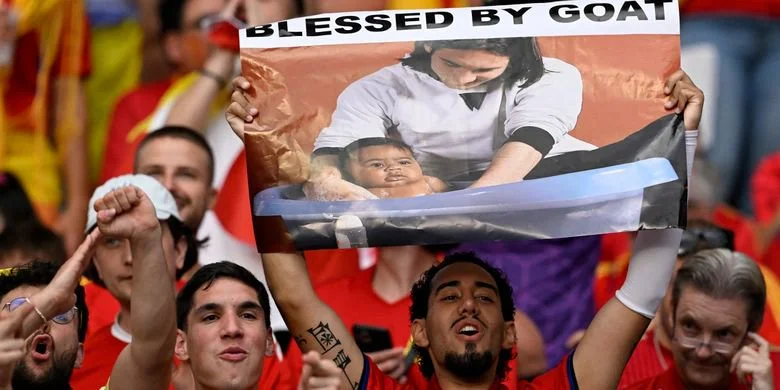 Seorang suporter Spanyol membentangkan poster menggambarkan bintang Argentina, Lionel Messi, memandikan penyerang Spanyol, Lamine Yamal, dalam sesi pemotretan amal di ruang Barcelona pada 2007.