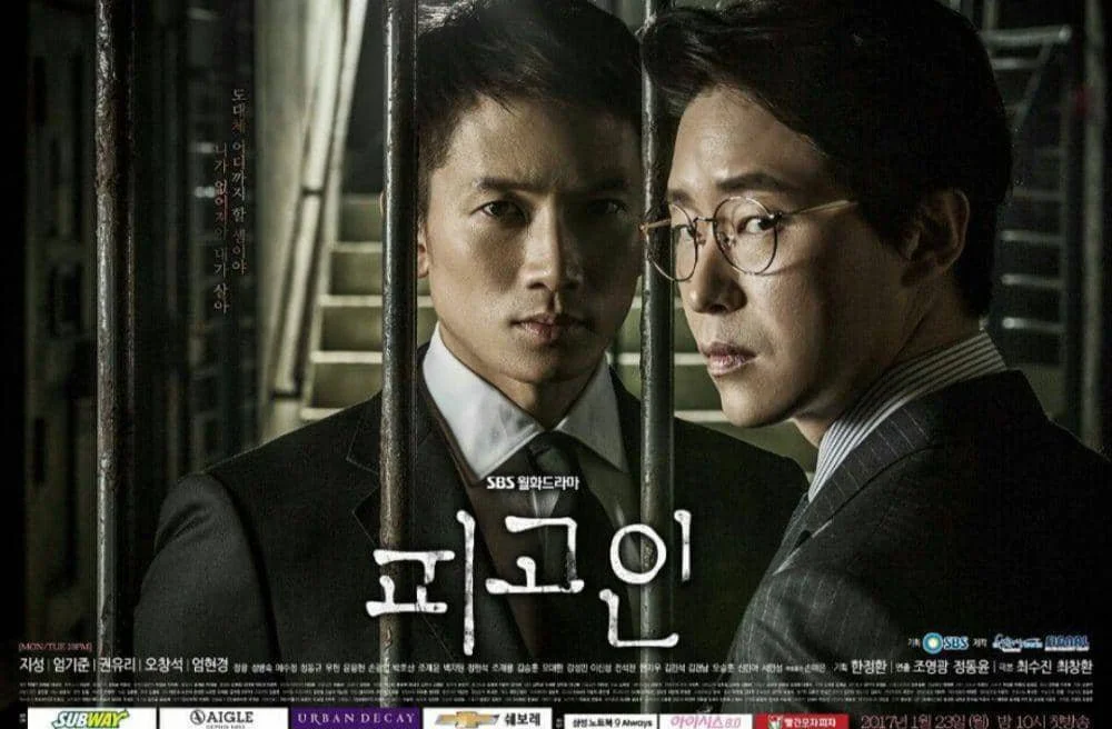 Poster drama Korea Defendant menampilkan dua pria berpakaian jas berdiri di balik jeruji besi dengan ekspresi serius dan tegang.