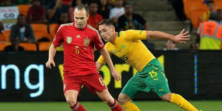 Andres Iniesta mencoba melewati Andile Jali dalam pertandingan persahabatan antara tuan rumah Afrika Selatan vs Spanyol yang berlangsung di Stadion Soccer City, Johannesburg, Rabu (20/11/2013)