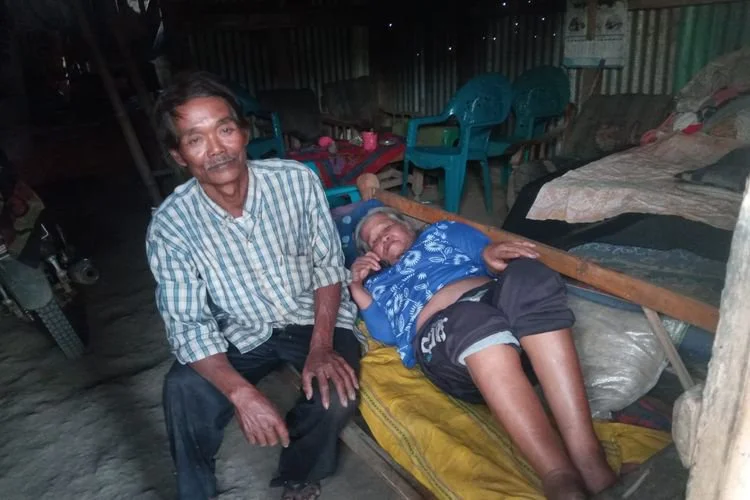 Bugira (68) tiga tahun stroke didampingi suaminya, Saniman alias Pak Nur di rumahnya Padukuhan Dampikrejo Dusun Baban Timur, Desa Mulyorejo, Kecamatan Silo, Kabupaten Jember, Jawa Timur.