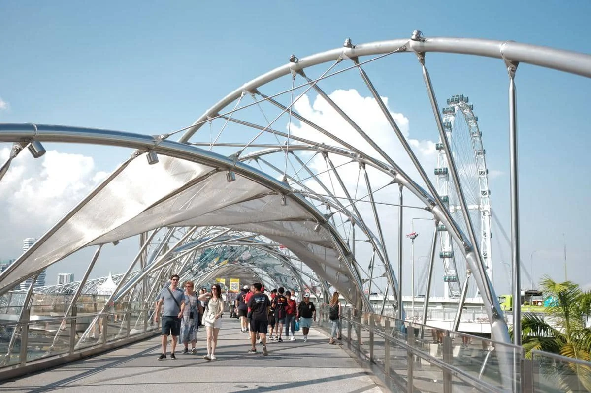 Para pengunjung berjalan-jalan di sepanjang Jembatan Helix di Singapura.